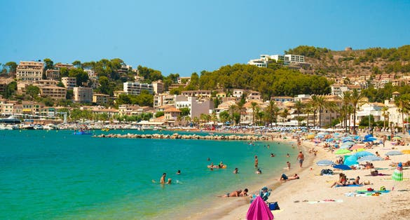 Colorful umbrellas on Puerto de Soller, Port of Mallorca island in balearic islands, Spain. Beautiful picture of people resting on the beach on bright summer day.