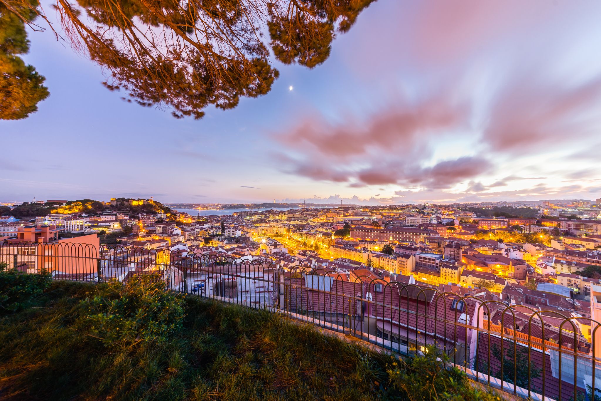 Photo of city view of Lisbon after sunset from Belvedere of Our Lady of the Mount or Miradouro da Nossa Senhora do Monte, Portugal.