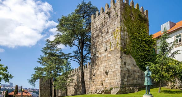 Photo of Medieval Fernandine Wall of Sé and Arnaldo Gama Statue in Porto, Portugal.