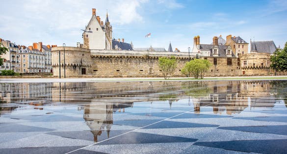 photo of the castle of Dukes of Brittany with Miroir d'eau (water mirror fountain) at beautiful morning in Nantes city in France.