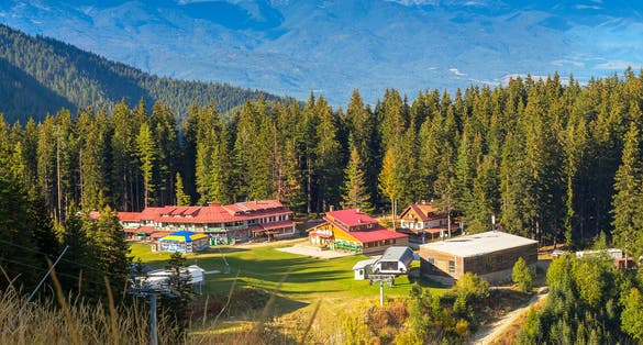 Photo of Bansko, Bulgaria Shiligarnika autumn ski resort view with hotel house, mountains and ski lift.