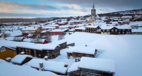 photo of view of Wintertime in Roros, mining old town. Original wooden architecture covered by snow. Cold winter scenery.