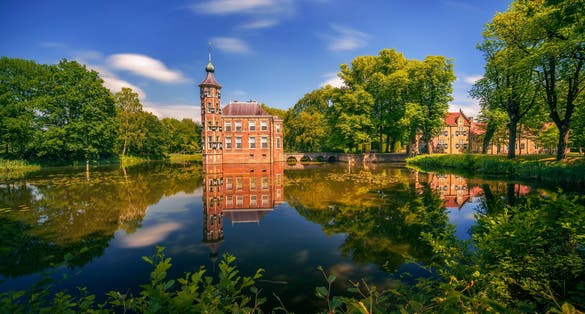 photo of Breda Castle and the surrounding park with reflection in water situated near the Dutch city of Breda in Netherlands.