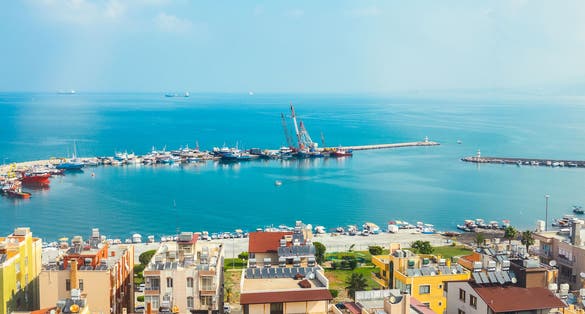 Industrial port or harbor with container or cargo ships and cranes in iskenderun seaport at Hatay city of Turkey. Transportation and logistic at Mediterranean sea.