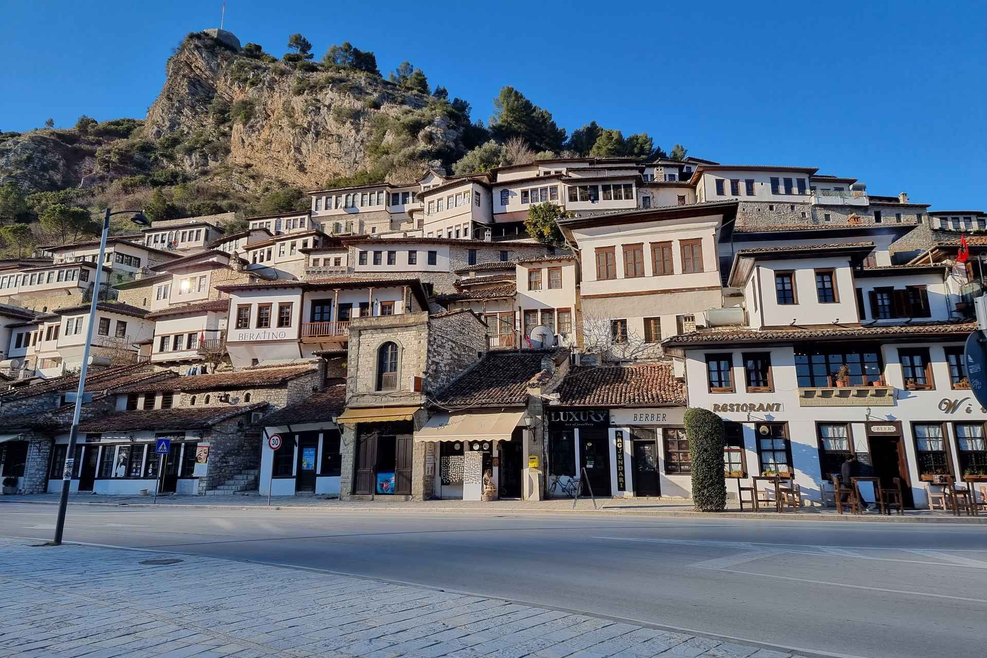 A hillside town in Berat, Albania, with white Ottoman-style houses and stone buildings under a clear blue sky..jpg