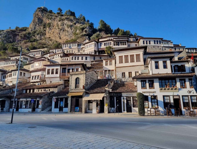 A hillside town in Berat, Albania, with white Ottoman-style houses and stone buildings under a clear blue sky..jpg