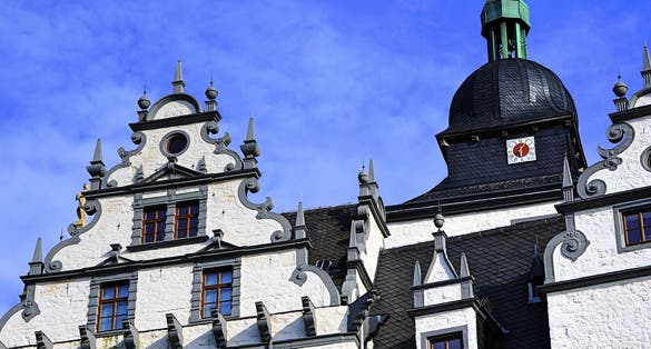 photo  of view of The historical building. The castle in the city of Wolfsburg. Germany. against the blue sky. calaxery and clock.