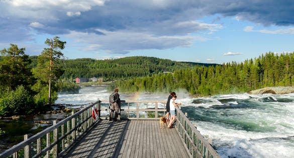photo of tourists watching the Ristafallet waterfall in Hålland in Sweden.