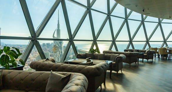 Photo of the interior of the restaurant on the top of the famous Alphabet tower at historical center. The window offers a beautiful view of the black sea and the building old city, Batumi, Georgia.