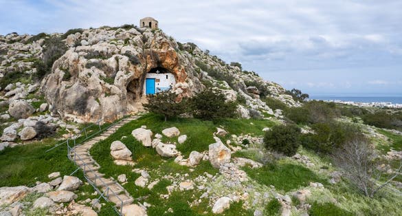 Photo of aerial view of Agioi Saranta cave church built in mountain in Protaras, Cyprus.