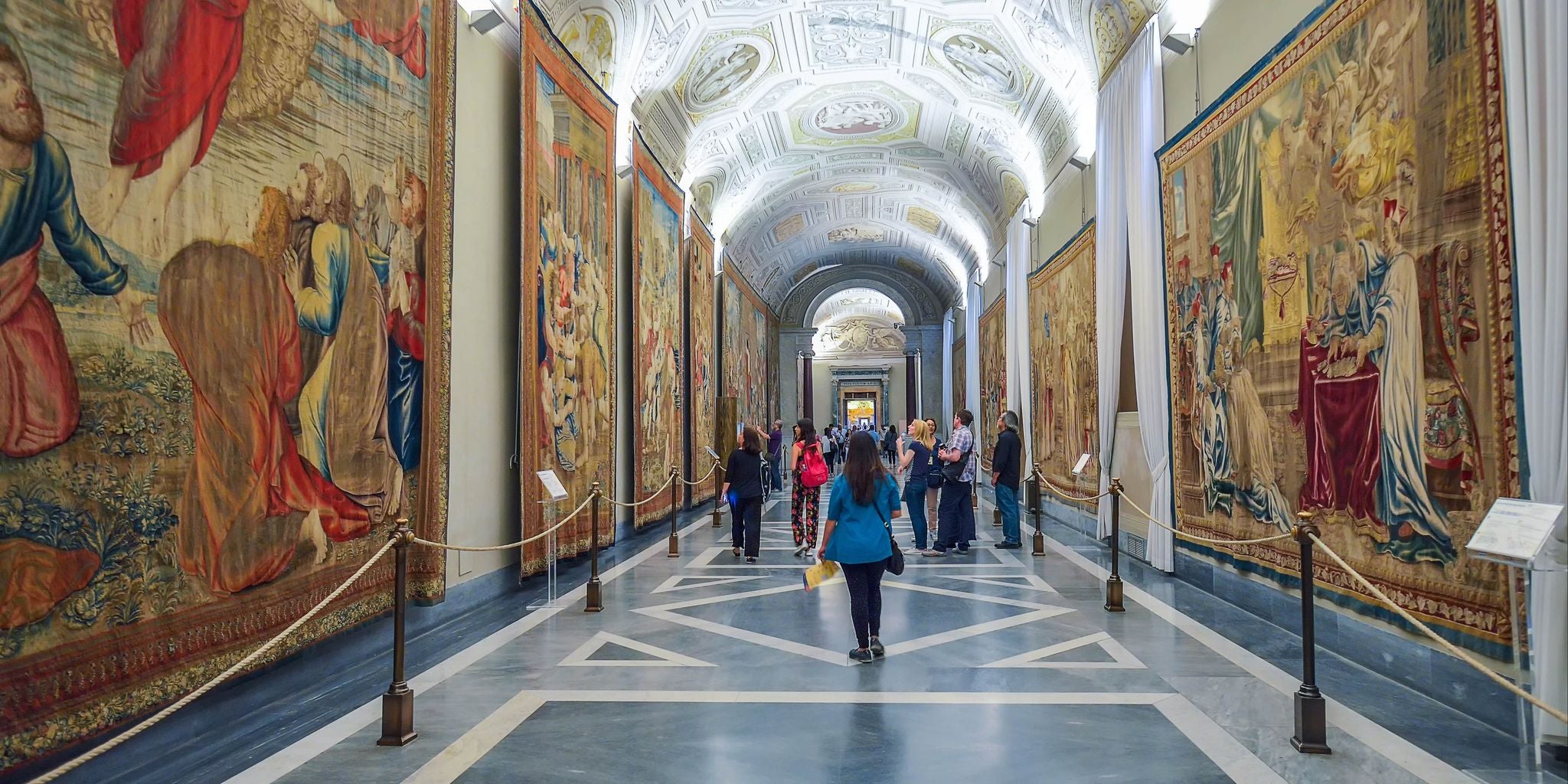 Visitors exploring the Gallery of Tapestries in the Vatican Museums in Italy..jpg