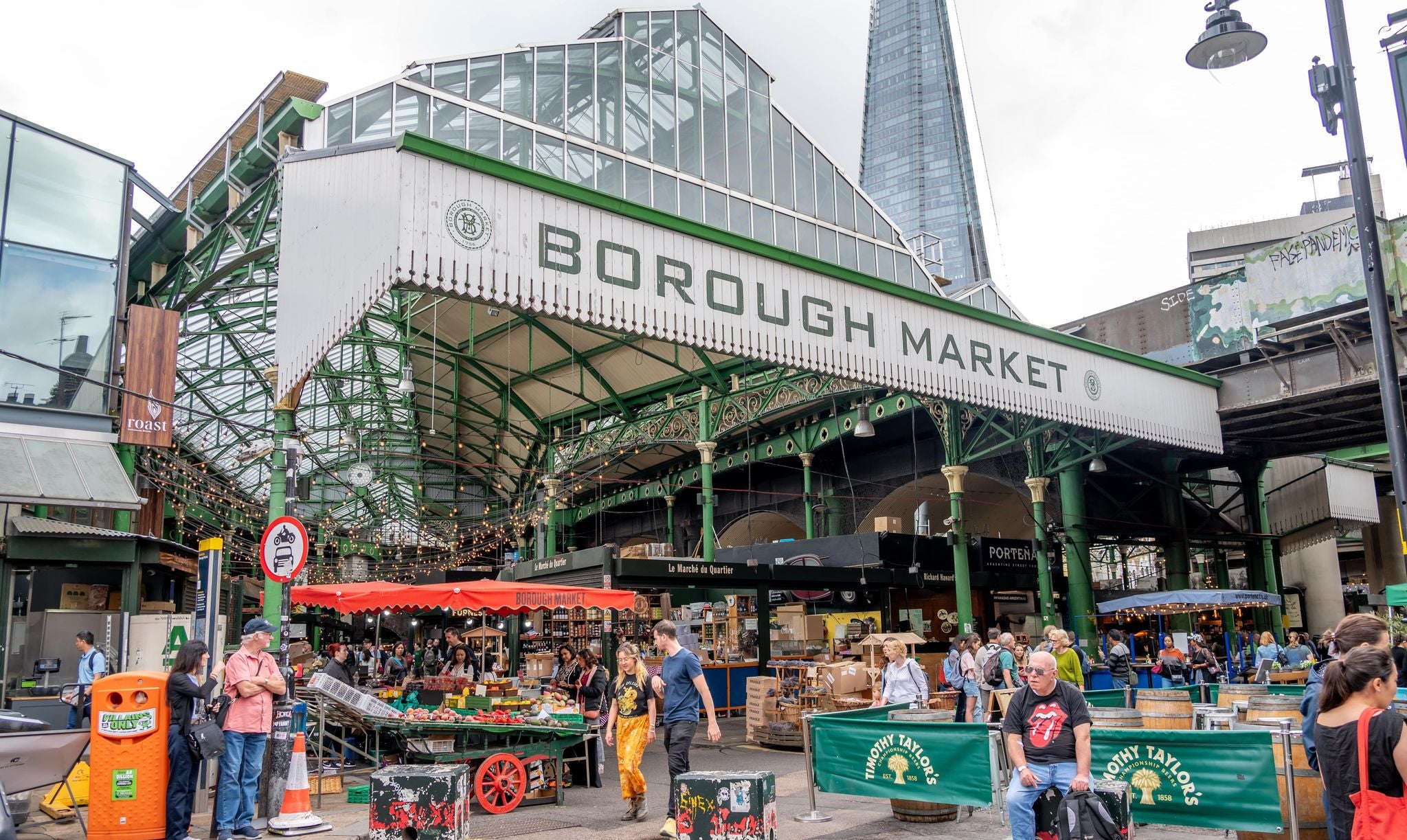 Crowds browsing fresh produce and food stalls at Borough Market under its iconic green iron structure..jpg