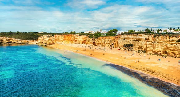 Photo of beautiful sandy beach surrounded with cliffs called Praia Nova, Porches, Algarve, Portugal.