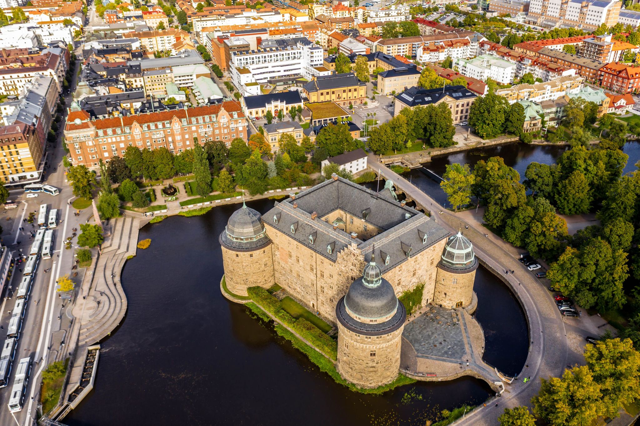 photo of a drone shot of the beautiful Orebro Castle surrounded with Svartan river and the cityscape in Örebro County, Sweden.