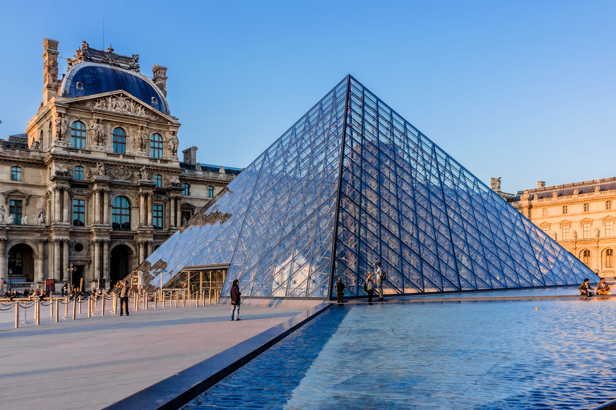 Photo of Pyramid in Louvre Museum at sunset, France.