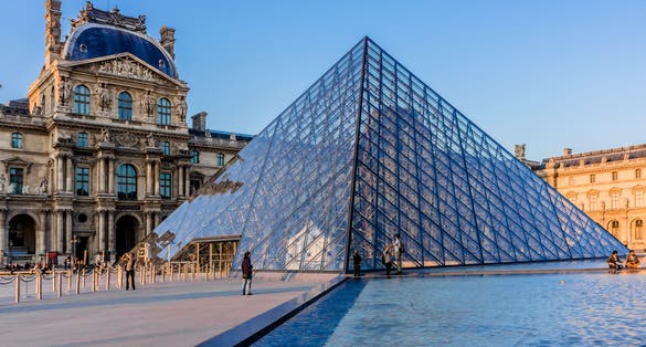 Photo of Pyramid in Louvre Museum at sunset, France.