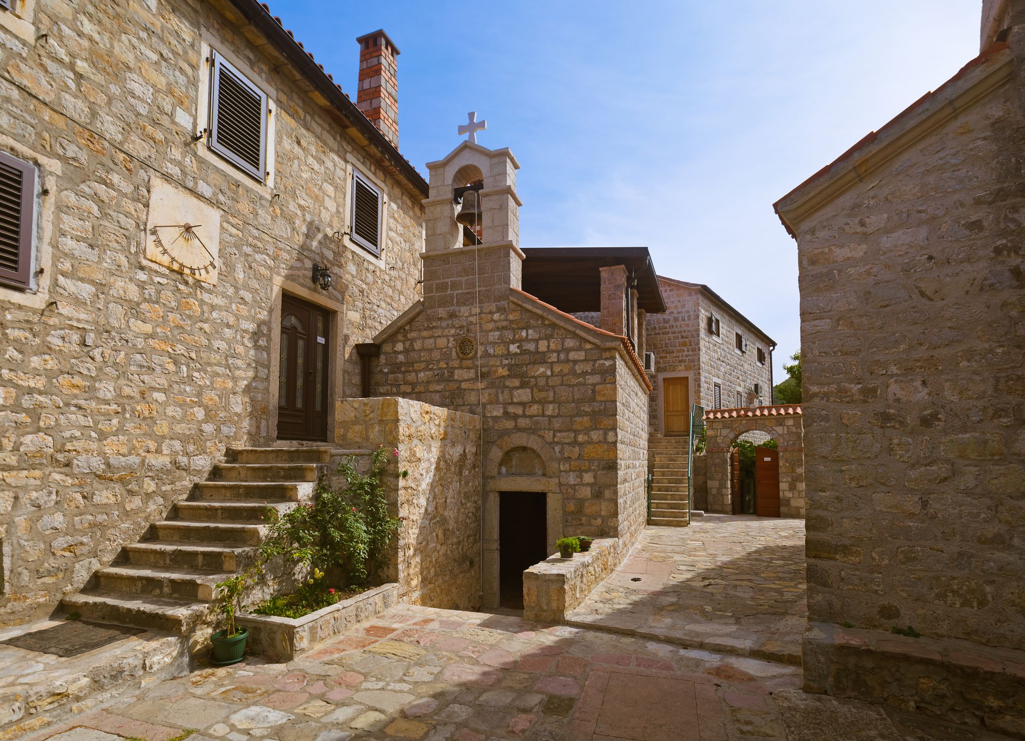 Photo of Rezevici abbey is situated between Budva and Petrovac, Montenegro.Stone belfry and facade of The Serbian Orthodox Rezevici Monastery.