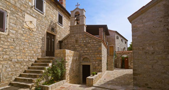 Photo of Rezevici abbey is situated between Budva and Petrovac, Montenegro.Stone belfry and facade of The Serbian Orthodox Rezevici Monastery.