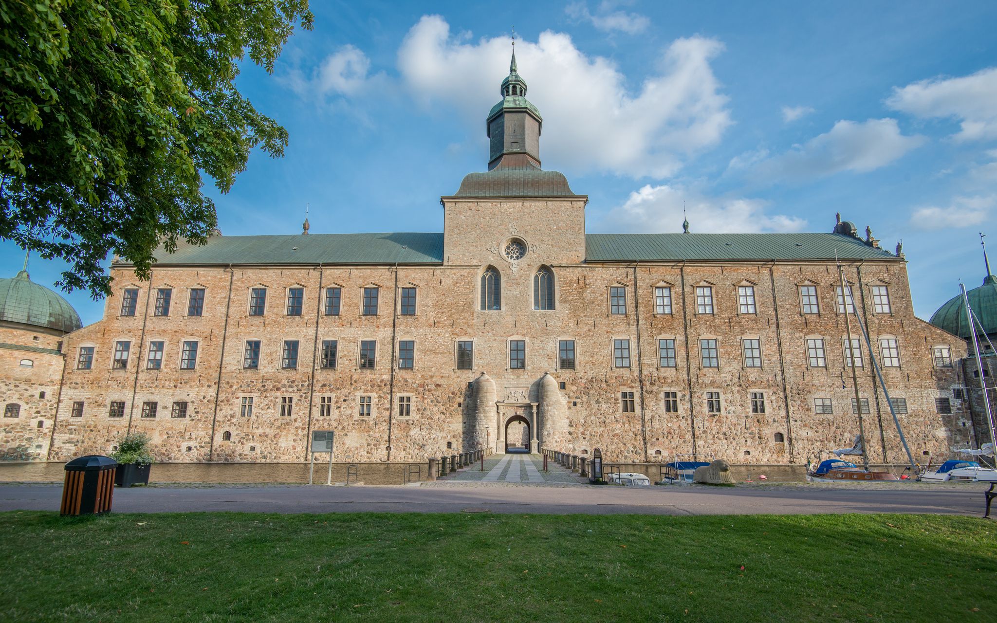 photo of Vadstena Castle and park in Sweden. View from outside the landmark. Entry to the inside by a bridge.