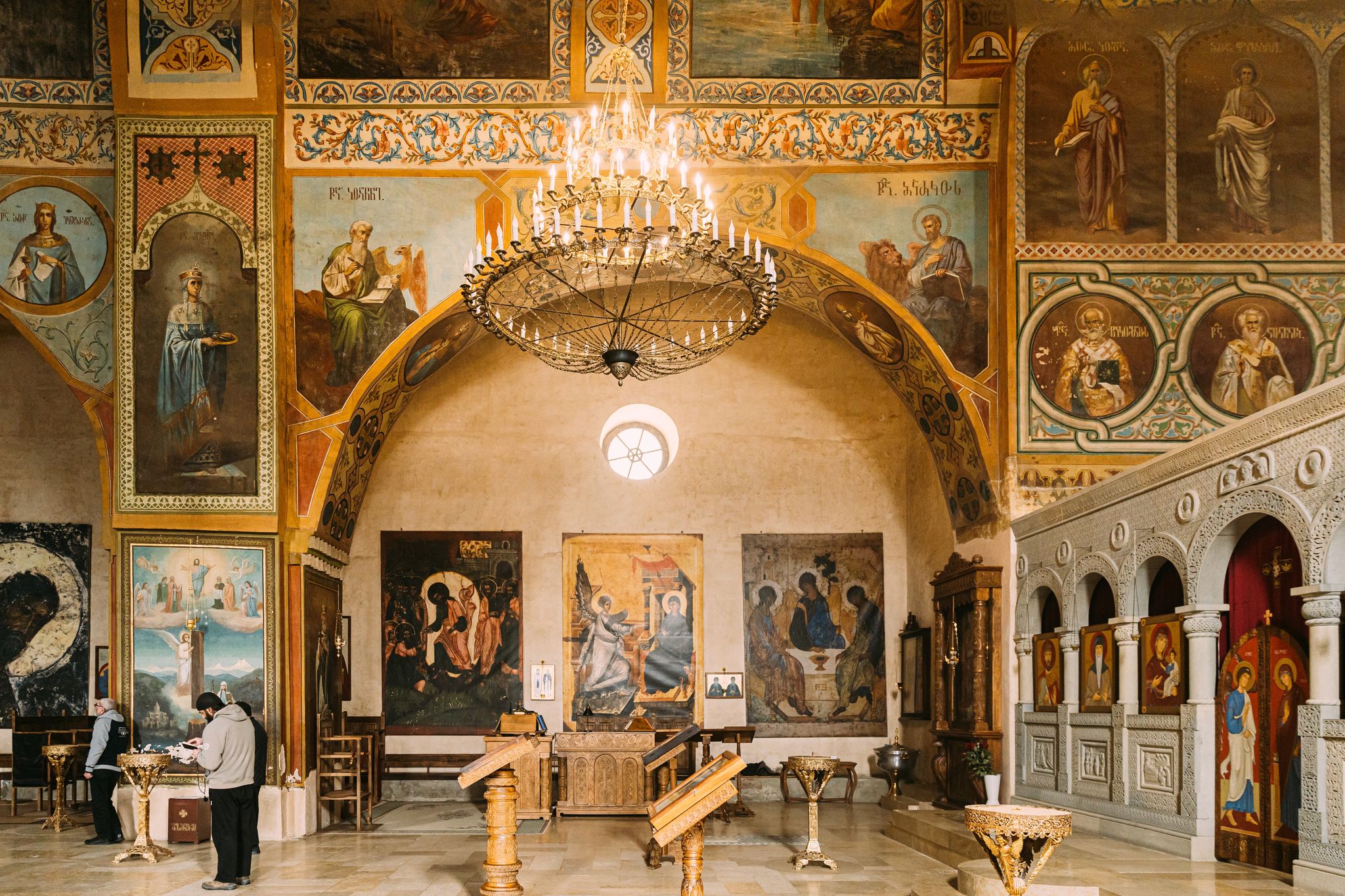 Photo of people praying in Shio-Mgvime Monastery. interior of Upper Church Of Holy Virgin Or Theotokos, Central Part Of Medieval Monastic.