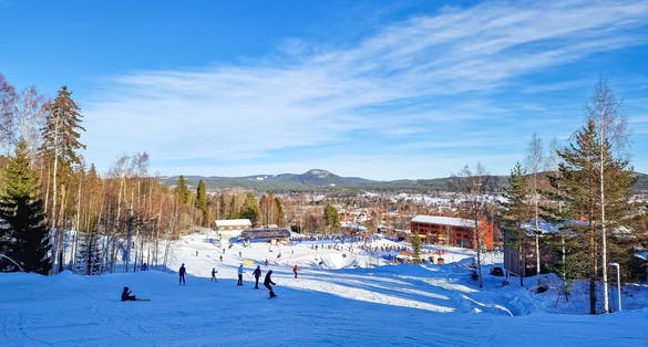 photo of skiers on a ski slope leading to the ski lift at Järvsöbacken ski resort in Järvso, Sweden.