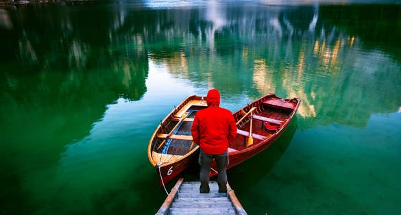photo of Man alone at the Braies Lake ( Pragser Wildsee ) in Dolomites mountains, Sudtirol, Italy,Prags - Braies Italy.