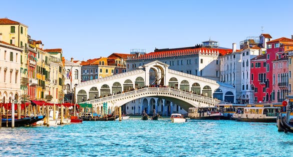 photo of view of View of Grand Canal with Rialto Bridge and gondoliers in Venice, Italy. Landscape with Rialto Bridge and gondola on the Grand Canal in Venice, Italy, Europe.