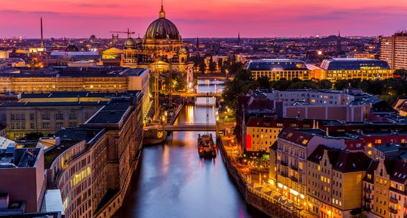 Panoromic aerial view of Berlin skyline with famous TV tower and Spree river in beautiful post sunset twilight during blue hour at dusk with dramatic colorful clouds , central Berlin Mitte, Germany
