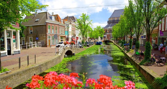 Picturesque Delft cityscape view with Eastern Gate Oostport and canal with cars and bicycles parked along. Delft, Netherlands's