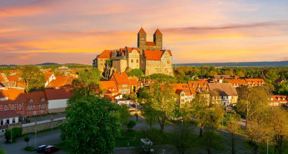 photo of view of Quedlinburg Castle over old town at sunset, Germany.