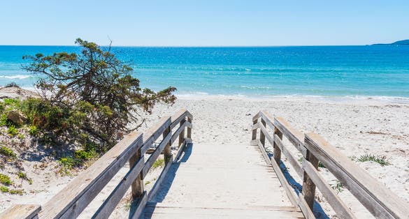 Photo of wooden bordwalk in Maria Pia beach. Alghero, Sardinia, Italy.