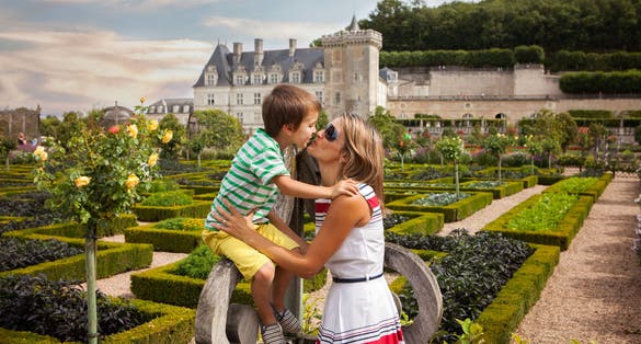 photo of beautiful mother and son in front of Villandry castle, in the gardens, Centre, France on sunny day.
