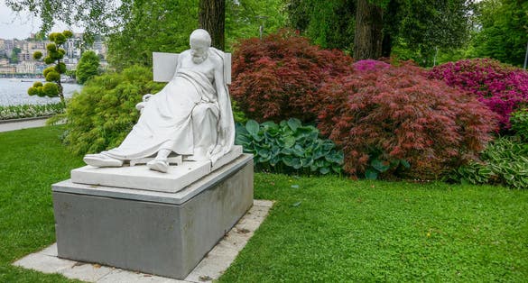 Photo of White stone sculpture of the dying Greek philosopher Socrates, dating from 1876 AD, in the Parco Ciani (Ciani Park) in the city of Lugano, Ticino, Switzerland.