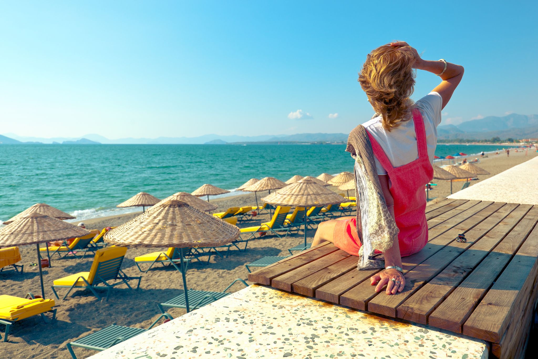 Photo of tourist woman enjoying amazing view of Calis Beach in Fethiye, Mugla Province, Turkey.