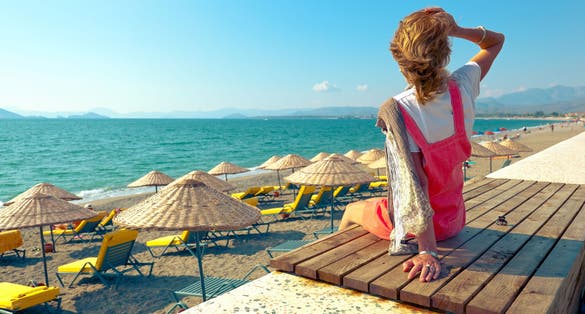 Photo of tourist woman enjoying amazing view of Calis Beach in Fethiye, Mugla Province, Turkey.