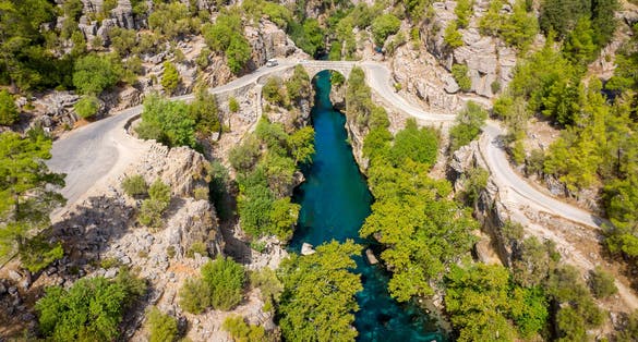 photo of aerial view of ancient arch bridge Oluk over the Koprucay river gorge in Koprulu national Park in Antalya, Turkey.