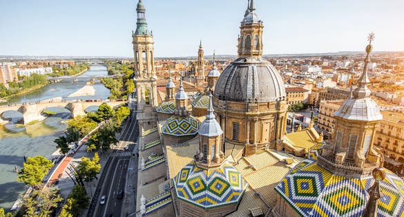 Photo of aerial cityscape view on the roofs and spires of basilica of Our Lady in Zaragoza city in Spain.