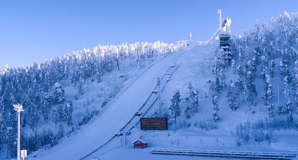 Photo of the Ruka ski area with the big ski jump and several lifts around the Rukatunturi fell on a snowy day.