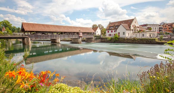 photo of beautiful sunny morning at the medieval bridge over the Reuss river in the town of Bremgarten in Switzerland.
