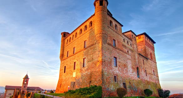 photo of Golden hour view of Grinzane Cavour castle, historical landmark, village in Langhe region, Cuneo, Piedmont, Italy.