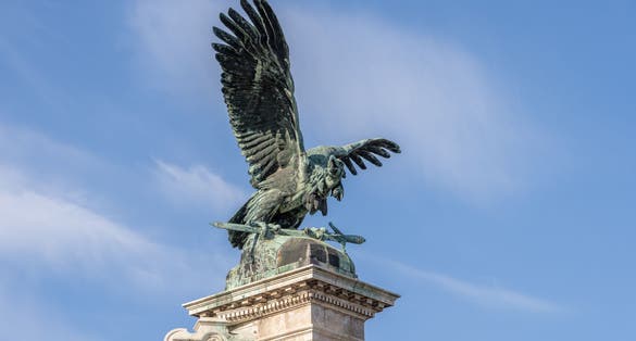 photo of view of Bronze turul Bird statue on top of column at Sandor Palace on Buda Hill in Budapest winter morning, Tatabánya, Hungary.