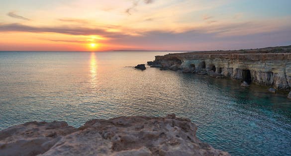 Photo of beautiful sunset with spectacular colours, a fantastic sky and an unobstructed view of the sea at the sea caves of Ayia Napa.