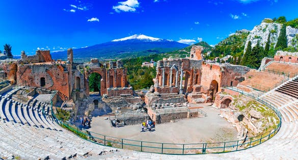 photo of Taormina, Sicily, Italy: The Greek Theater of Taormina with smoking Etna volcano in background, in a beautiful day of summer