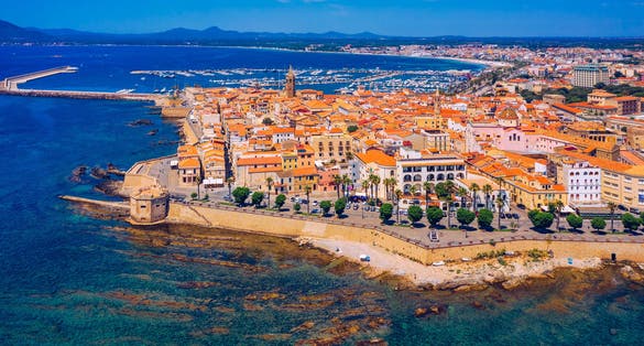 Photo of aerial view of Alghero on a beautiful day with harbor and open sea, Italy.