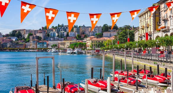 Photo of panoramic view of the lake Lugano, mountains and city Lugano, Ticino canton, Switzerland.