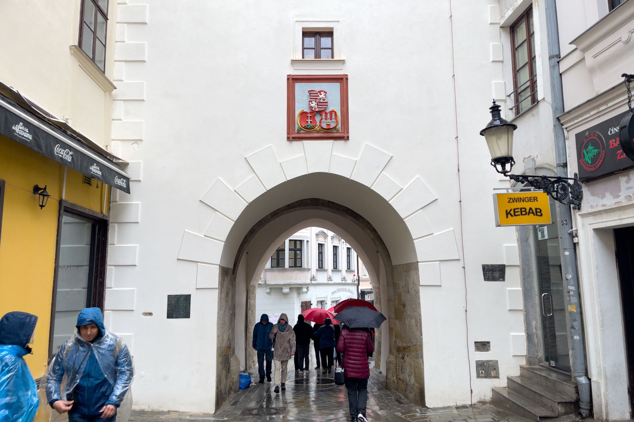 People walking through Michael's Gate in the old town of Bratislava, Slovakia