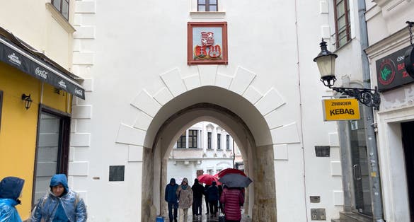 People walking through Michael's Gate in the old town of Bratislava, Slovakia