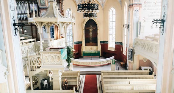 The interior of the Evangelical Lutheran Church of Joensuu. Neo-gothic style. Sunlit interior with empty benches