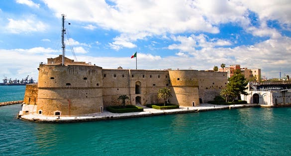 photo of Aragonese Castle of Taranto and revolving bridge on the channel between Big and Small sea, Puglia, Italy, Blue sunny sky