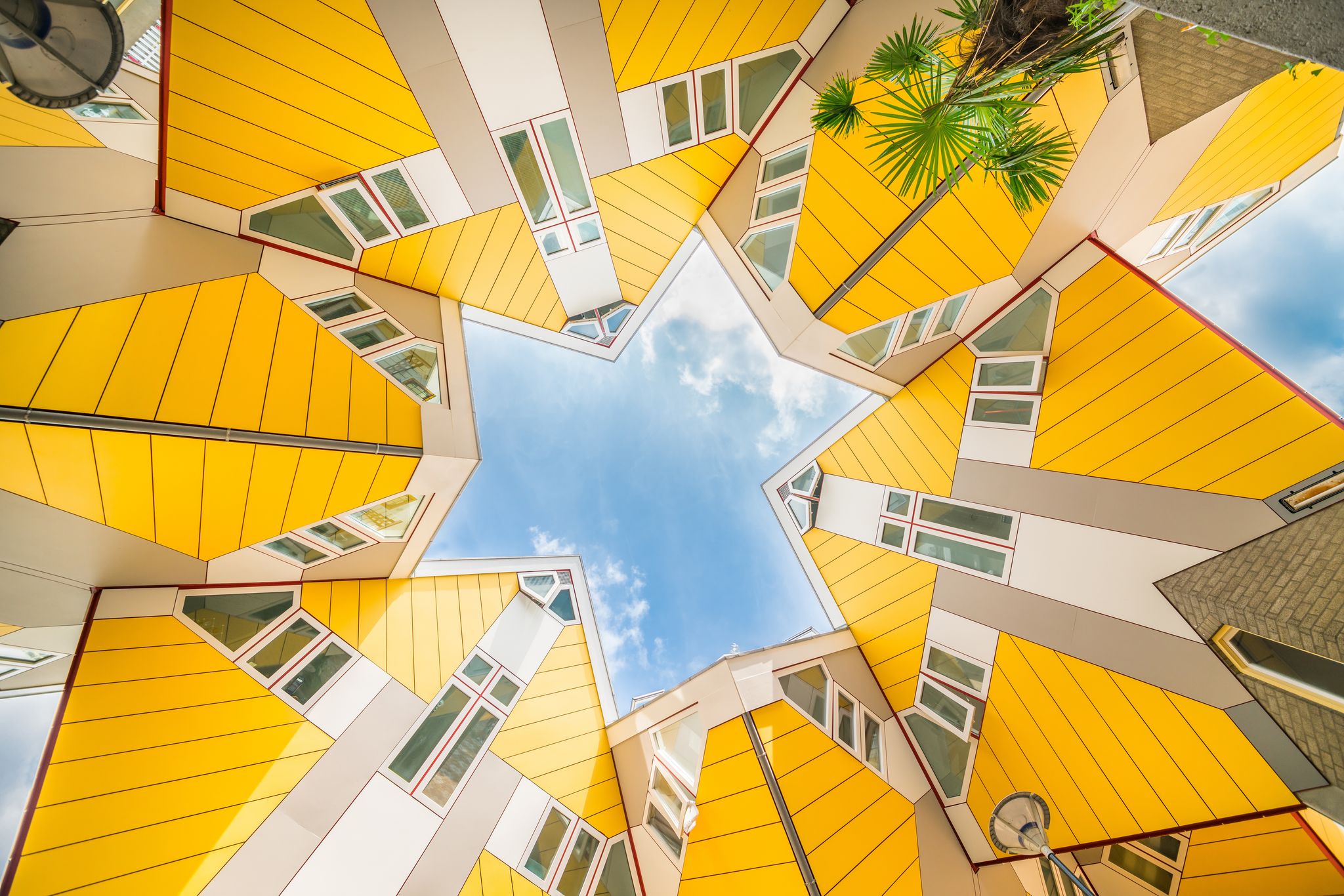 photo of star shapes formed where six Cube houses tilt into one another and intersect in Rotterdam, a quirky bright yellow architecturally unusual angular cube shape apartment block.